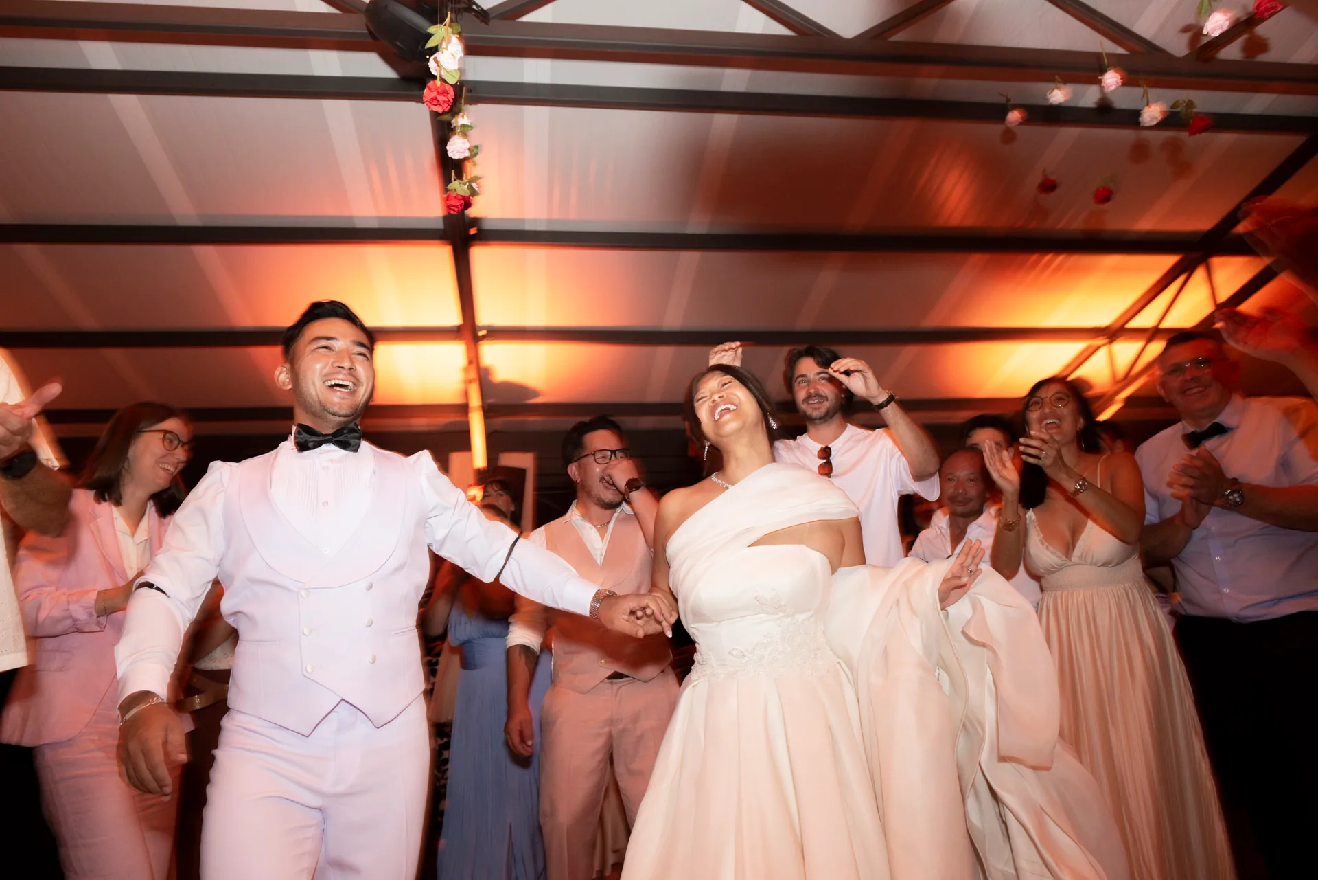 Les mariés dansent et rient entourés de leurs invités pendant la réception