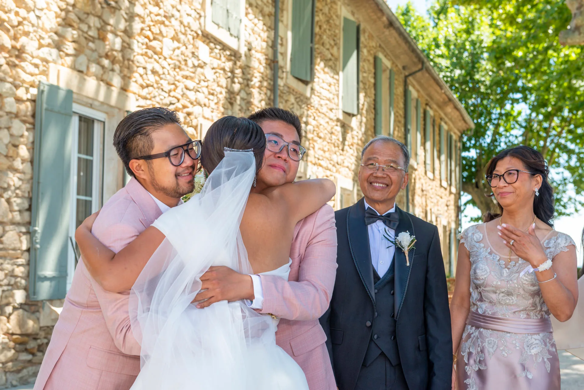 Les mariés entourés de leur famille devant la façade du domaine