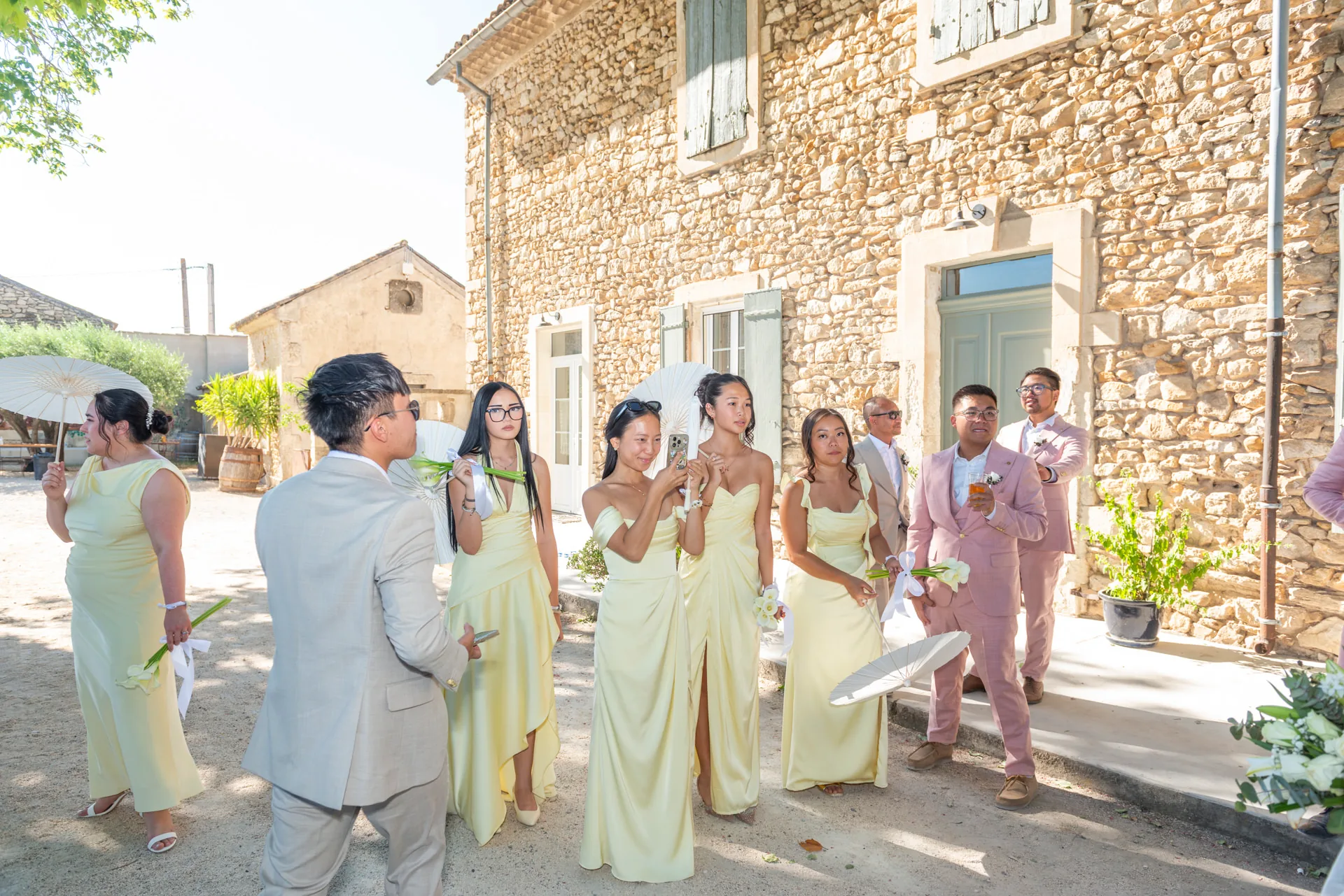 Des invités de mariage réunis devant une bâtisse en pierre en Provence