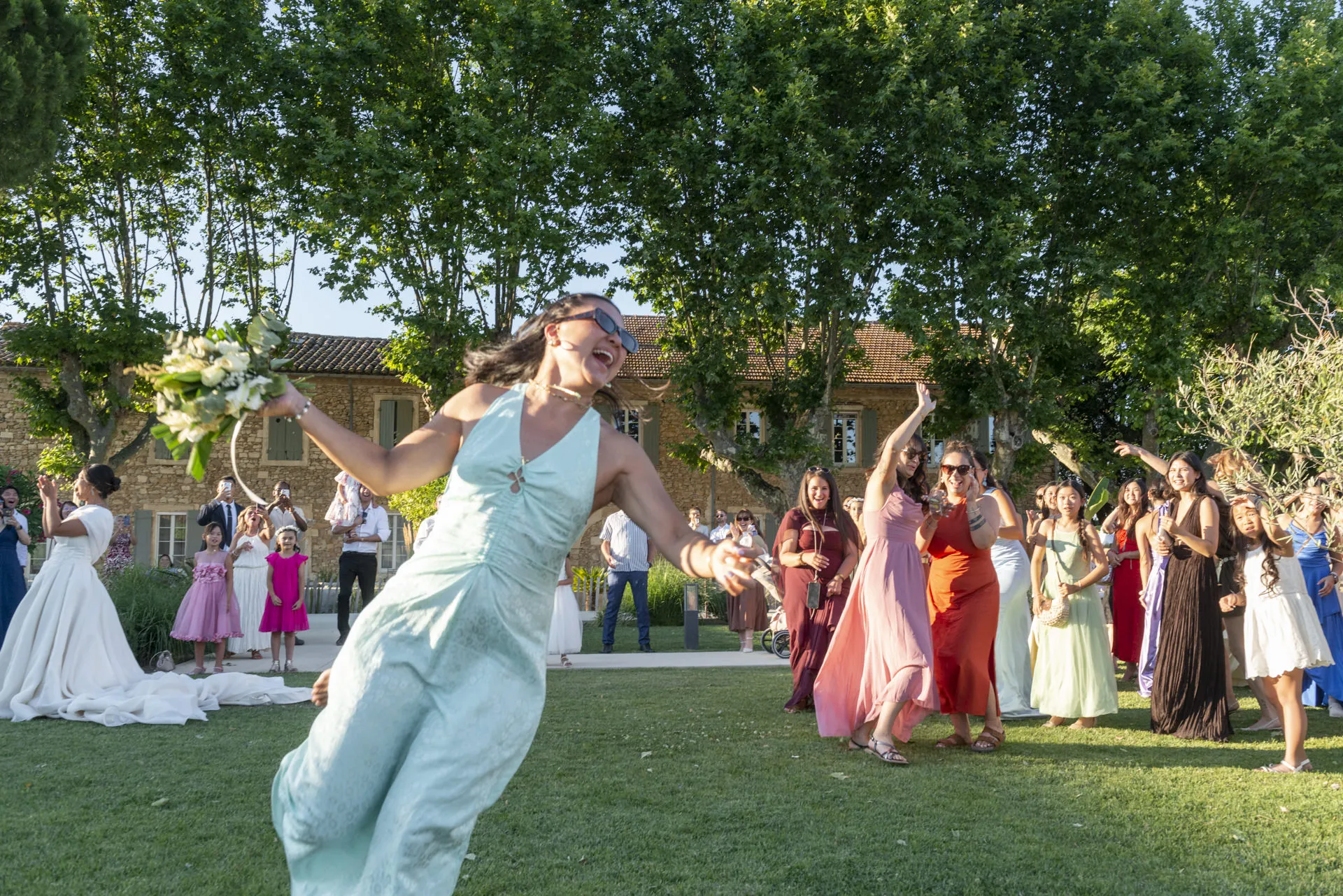 Une invitée attrape le bouquet lancé par la mariée, en noir et blanc