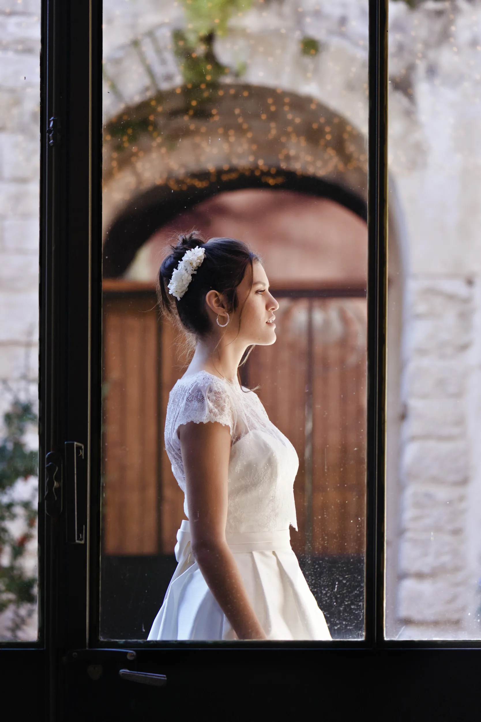 Mariée de profil dans la lumière d’une fenêtre pendant un mariage d’hiver