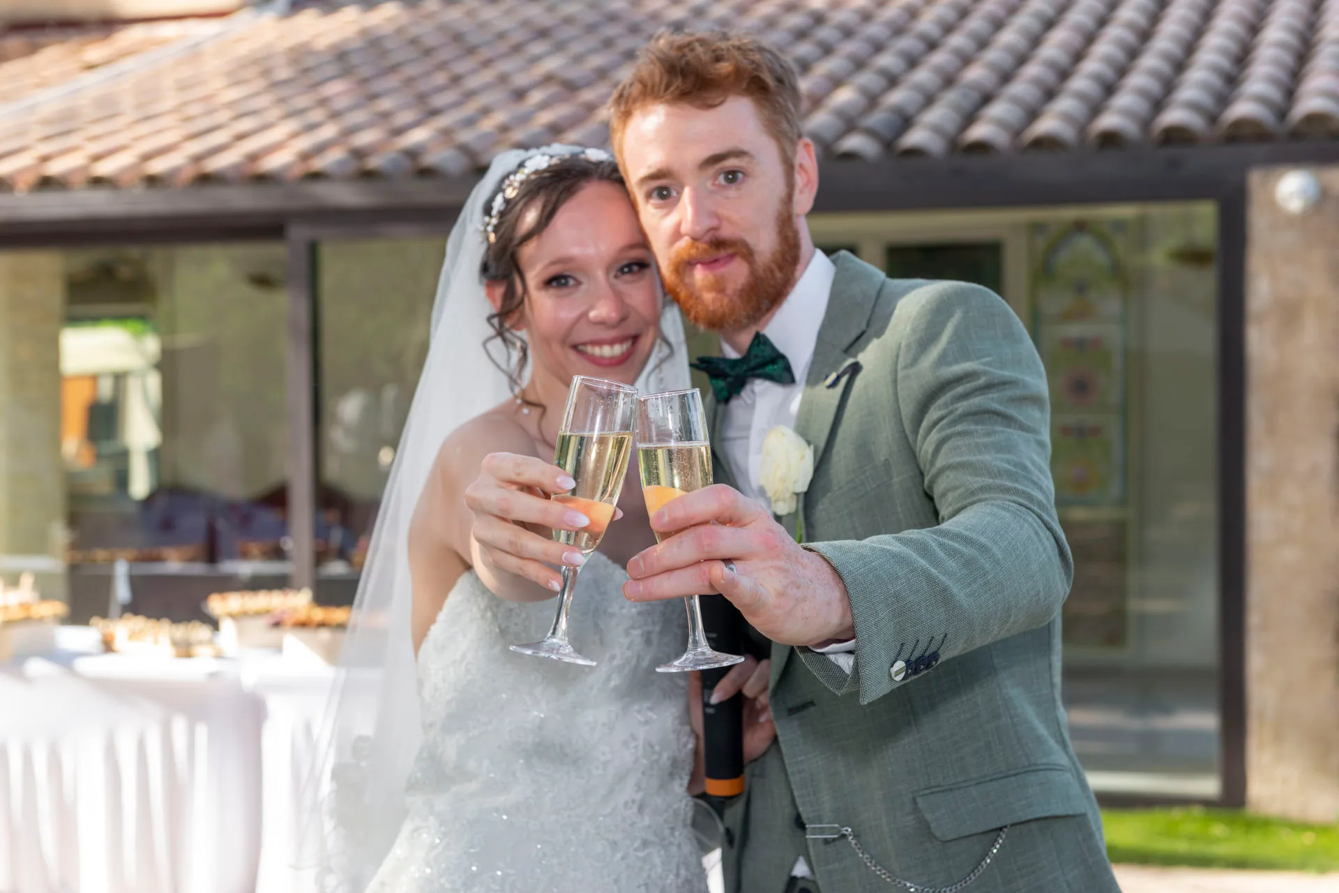 Les mariés sourient et portent un toast avec leurs coupes de champagne