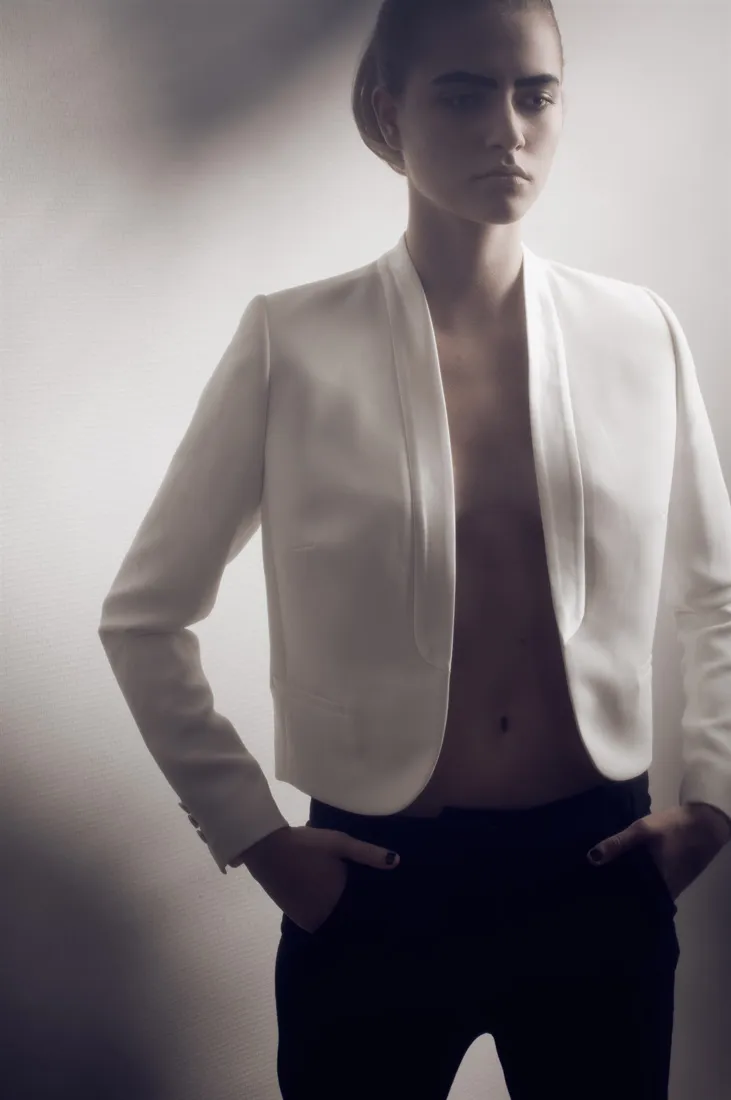 Modèle portant une veste blanche dans une photographie de mode épurée
